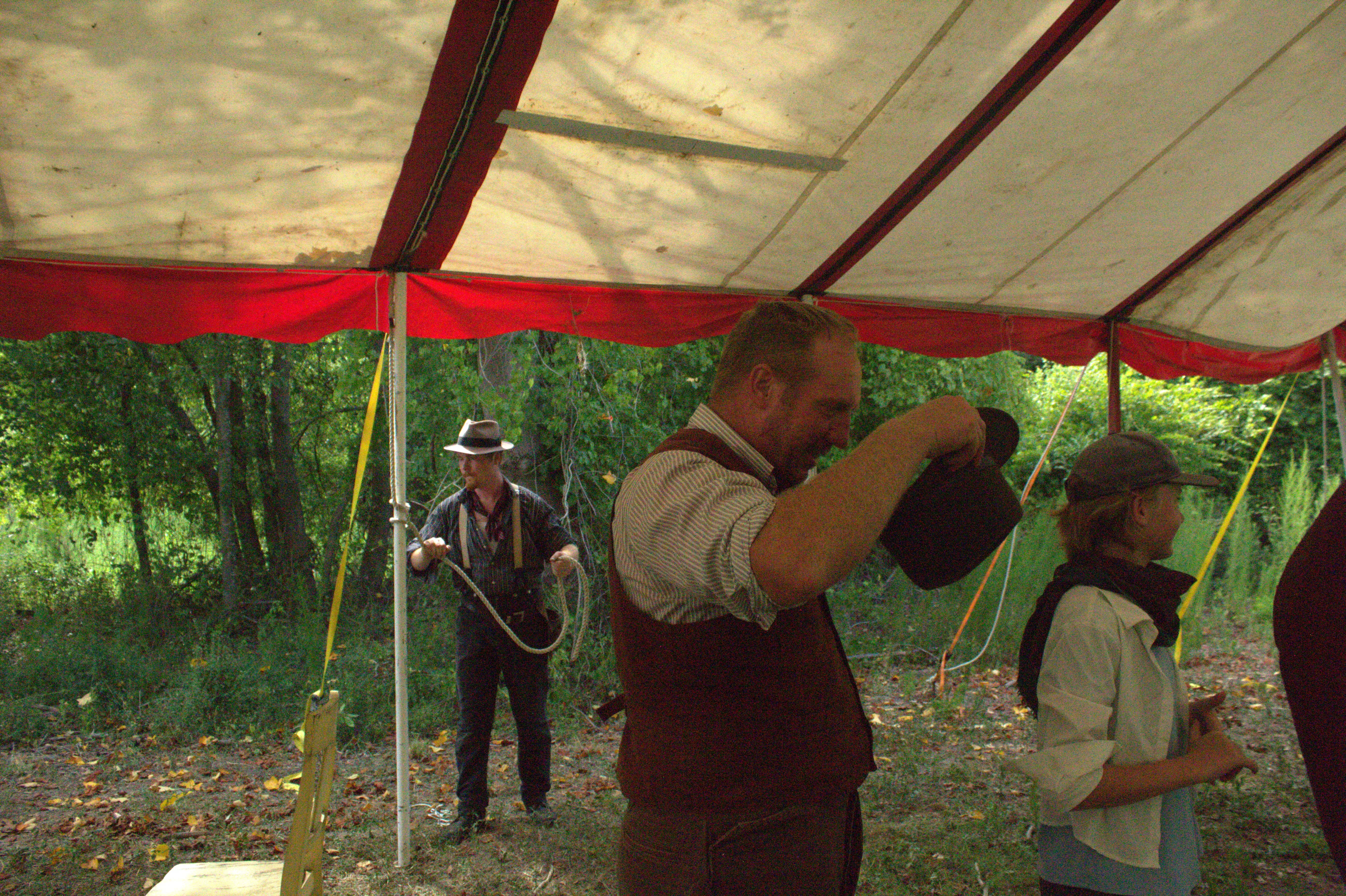 Crew raising the tent and coiling rope before a show