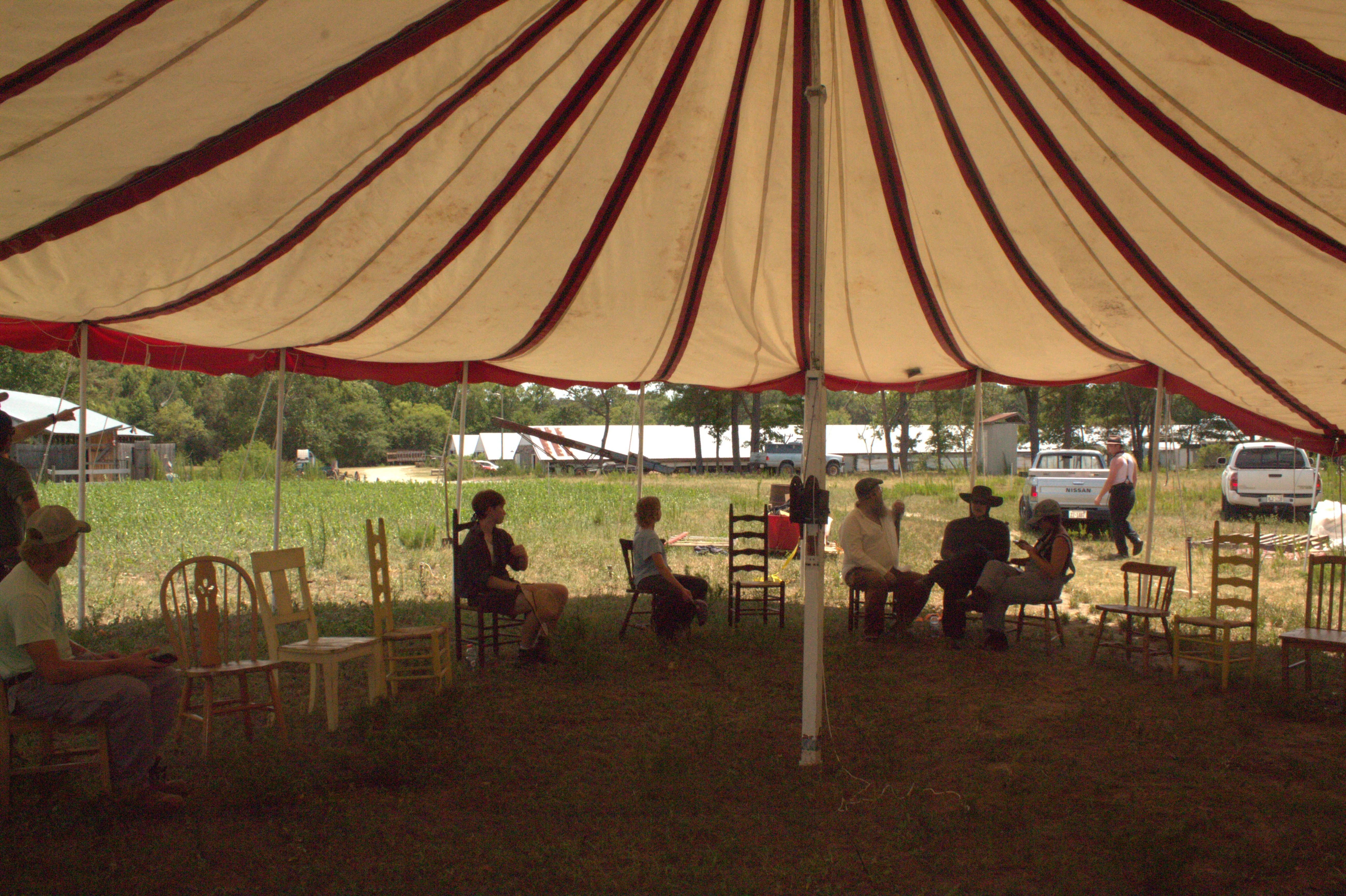 Two Kuroneko Circus performers in costume beside the tent sidewall on the lot in North Carolina